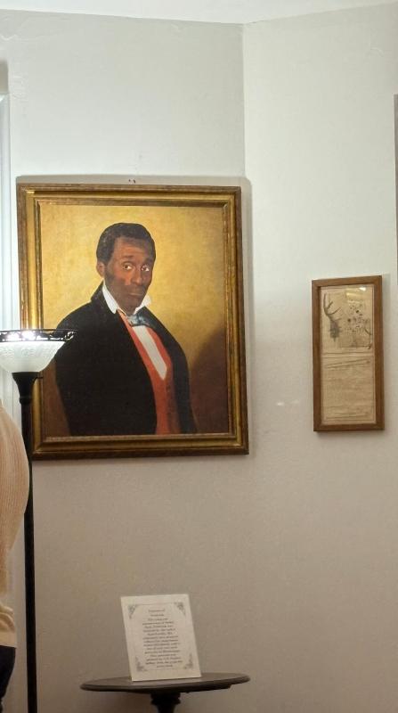 A photo of a replica of a famous portrait of an enslaved man named Frederick, one of the few portraits of an enslaved person painted in the United States. This replica currently hangs in the Longwood estate in Natchez, Mississippi.