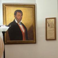 A photo of a replica of a famous portrait of an enslaved man named Frederick, one of the few portraits of an enslaved person painted in the United States. This replica currently hangs in the Longwood estate in Natchez, Mississippi.